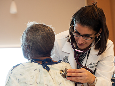student listening to patient's lungs in a hospital.